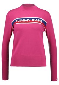 Fuchsia gestrickter Pullover mit hohem Kragen, gerippten Bündchen und Saum. Verfügt über ein horizontales "TOMMY JEANS"-Logo in Weiß, Rot und Blau über der Brust.