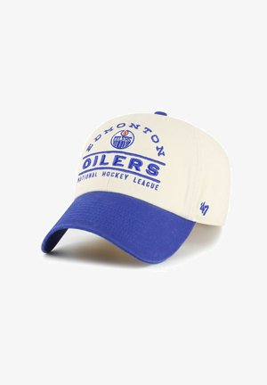 Cremefarbene Kappe mit blauem Schirm. Mit der Aufschrift "EDMONTON OILERS" in fetten blauen Buchstaben und darunter "NATIONAL HOCKEY LEAGUE". Enthält Logo.