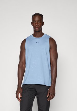 Light blue sleeveless athletic tank top with a subtle textured pattern and a small black logo on the chest, paired with black pants.