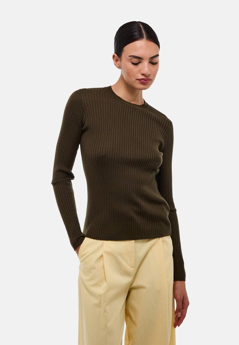 Pull à manches longues côtelé vert olive avec un col rond, associé à un pantalon taille haute de couleur jaune clair. Texture lisse, design ajusté.