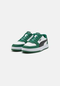 Hvide og grønne sneakers med overdel i læder, der har en polstret pløse, perforeret tåboks og sort logoaccent på siden.