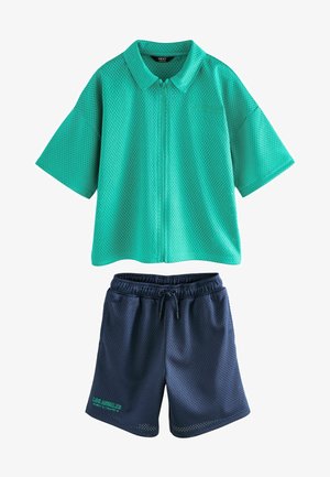 Cămașă verde din plasă cu mânecă scurtă și fermoar, cu guler, asortată cu pantaloni scurți din plasă bleumarin, cu siret și detaliu de text verde.