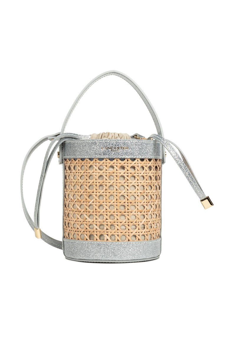 Petit sac seau avec bordure pailletée argentée, corps en rotin naturel tressé, fermeture à cordon beige en tissu et double poignées.