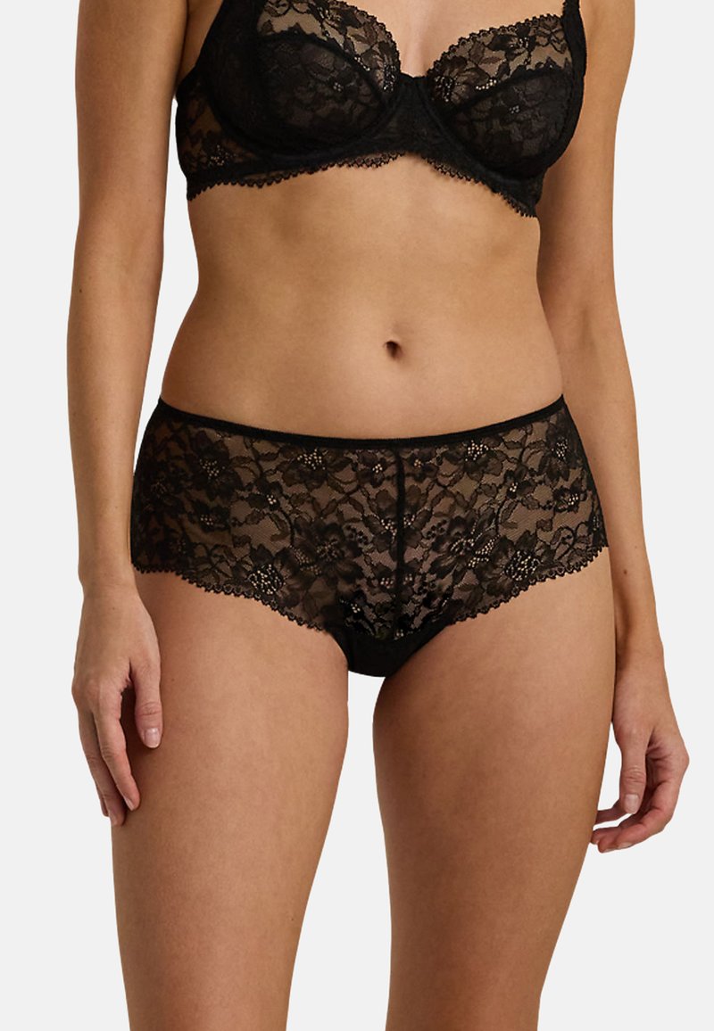 Svart spetsunderkläder set som består av en bh och shorts. Tygdetaljerna visar blommönster med vågiga kanter och en halvgenomskinlig design.