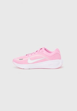 Zapatilla de correr Nike rosa con suela blanca y logo Swoosh blanco, mostrada sobre un fondo liso gris claro, vista lateral.