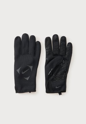 Paire de gants noirs Nike Therma-FIT, l'un montrant le dos avec le logo, l'autre la paume avec des motifs antidérapants, sur un fond clair.