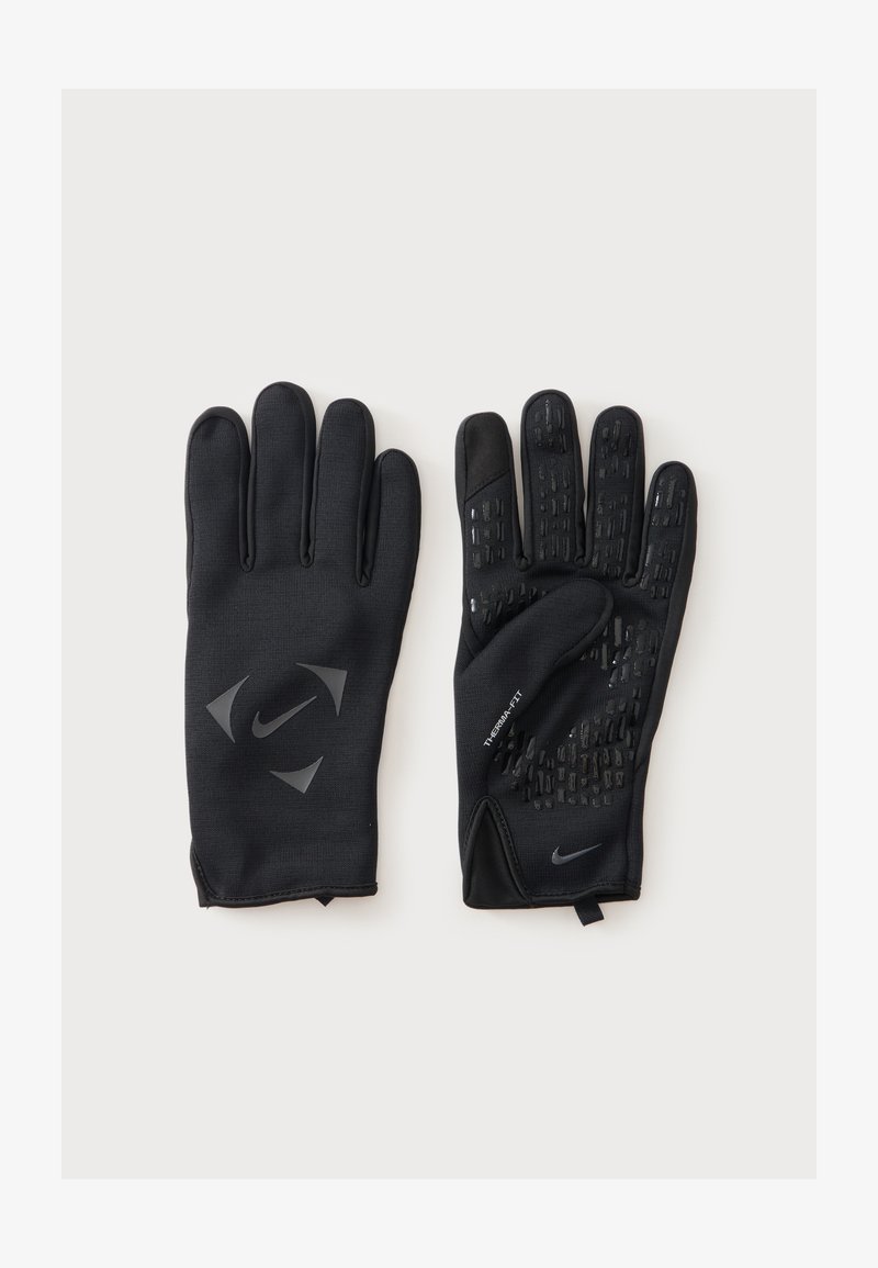 Ζευγάρι μαύρα γάντια Nike Therma-FIT, το ένα δείχνει την πίσω πλευρά με λογότυπο, το άλλο την παλάμη με μοτίβα για καλύτερο κράτημα, σε ανοιχτό φόντο.