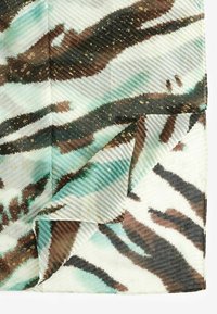 Colorful fabric with a striped tiger print in teal, brown, and white, featuring a textured surface and gold speckles. Folded corner displayed.
