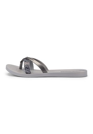 Graue Flip-Flop-Sandale mit metallischen und zebramusterten Riemen, flacher Sohle und Zehensteg, von der Seite auf weißem Hintergrund gezeigt.