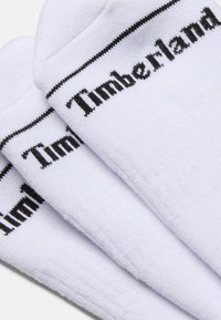 Calze in cotone bianche con un design senza cuciture, con il logo nero "Timberland" e un bordo nero a contrasto lungo la parte superiore.
