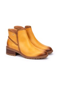Botas de tobillo de cuero color marrón claro con un acabado suave, costuras en contraste, punteras redondeadas y tacones cortos en bloque, con detalles laterales.