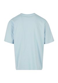 Gaiši zils kokvilnas T-krekls ar īsām piedurknēm, apaļu kakla izgriezumu un brīvu piegriezumu; gluda tekstūra, bez redzamām rakstu vai rotājumu detaļām.