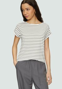 Gestreept katoenen t-shirt in het wit met smalle zwarte strepen, ronde halslijn en opgerolde korte mouwen, gecombineerd met grijze broeken met elastische tailleband.