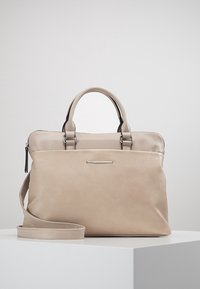 Beige Lederhandtasche mit doppelten Griffen, abnehmbarem Schulterriemen, Reißverschluss, silberfarbenen Beschlägen und glatter Textur.