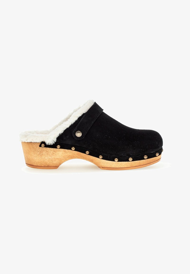 Black suede clog with white faux fur lining, wooden base, and metal studs along the edge. Classic open-back design with a rounded toe.