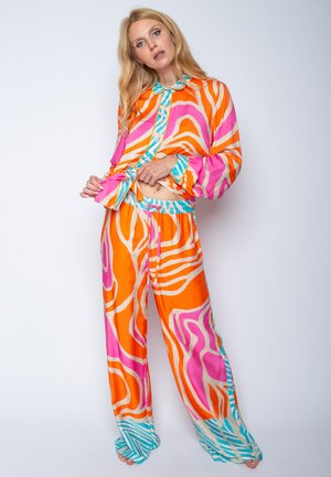 Zweiteiliges Loungewear-Set mit lebhaften, abstrakten Mustern in Orange, Pink und Türkis. Der Stoff ist glatt; das Oberteil hat ein Knopfleisten-Design.