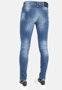Slim-fit denim jeans in lichtblauw met een vervaagde wassing, voorzien van twee achterzakken en een merkpatch van zwart leer op de taille.