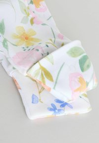 Valge kangast ese voltisäärisega, millel on peen kollase, roosa, sinise ja rohelise lillemustriga helel taustal.