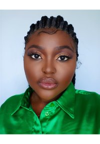 Chemise en satin vert brillant à boutons, avec un col, portée par une personne aux tresses, présentant un maquillage soigné, des cils audacieux et une texture de peau lisse.