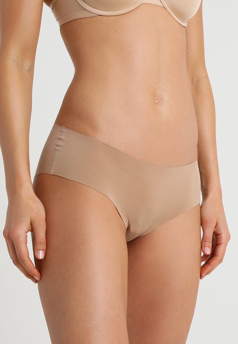 Bež bezšavne gaćice od glatkog, laganog materijala, sa niskim strukom i minimalnom pokrivenošću za elegantan izgled.