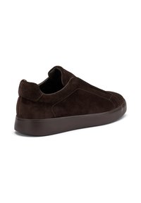 Zapato mocasín de ante marrón con punta redondeada y detalles de costura sutiles. Cuenta con una suela de goma oscura sólida y un logotipo en la parte trasera.