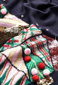 Gestrickter Pullover mit marineblauem Hintergrund, der ein buntes Weihnachtsbaum-Design, Paillettenakzente und Bommelverzierungen in Rot und Pink zeigt.