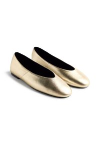 Ballerines en cuir doré avec un bout arrondi, texture lisse et un petit talon plat. Intérieur doublé de tissu noir. Pas d'embellissements visibles.