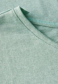 T-shirt in tessuto verde chiaro con design a V. Texture liscia con dettagli di cucitura fine lungo il collo.