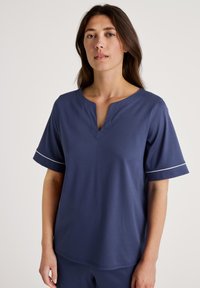 Marineblauwe T-shirt met korte mouwen en een V-hals. Het heeft een gladde textuur en een subtiele witte accent op de manchetrand. Gemaakt van lichtgewicht materiaal.