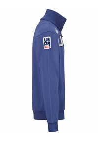 Pullover blu in tessuto morbido con colletto alto. Presenta un emblema degli Stati Uniti sulla manica sinistra e un grande logo stampato sul davanti.