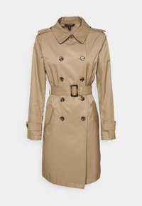 Beżowy płaszcz trencz o dwurzędowym kroju, z dużymi guzikami, szerokim kołnierzem, paskiem w talii oraz długimi rękawami z ozdobnymi guzikami.