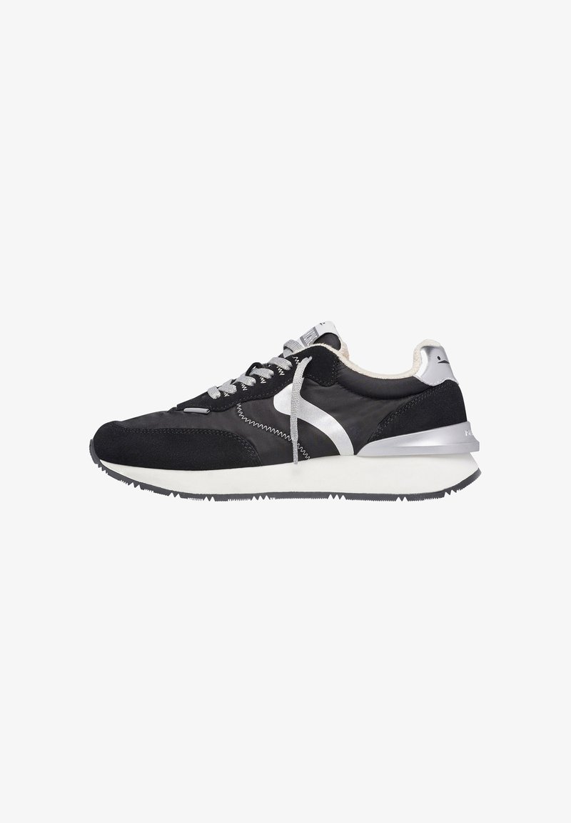 Black athletic shoes with suede and mesh materials, silver accents, and a white midsole. Features a lace-up design and textured outsole.