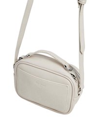 Bolso cruzado de cuero color crema con forma rectangular, que cuenta con un cierre con cremallera, un mango corto y una correa larga ajustable.