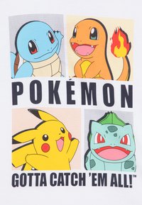 Vit t-shirt med fyra tecknade Pokémon: Squirtle, Charmander, Pikachu och Bulbasaur, med fet text "POKÉMON Måste fånga dem alla!"
