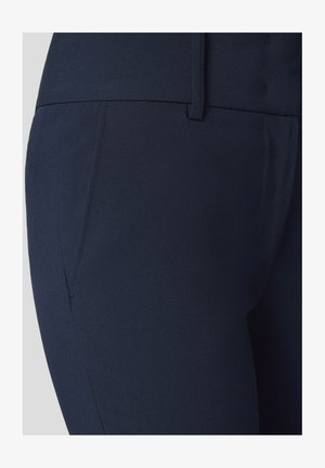 Granatowe spodnie wykonane z gładkiego materiału, z boczną kieszenią oraz dopasowanym krojem, z czystym pasem i detalami szwów.