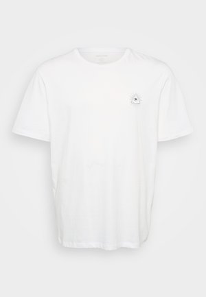 White cotton t-shirt featuring a round neckline and short sleeves. Notable graphic design of an eye surrounded by rays on the left chest.