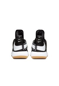 Scarpe da atletica nere con un upper testurizzato, dettagli bianchi, suola in gomma con suola in gomma naturale e dettagli del marchio sul tallone.