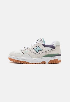 Witte en lichtblauwe New Balance 550 sneaker met geperforeerde zijkanten, gumzool en witte veters op een effen achtergrond.