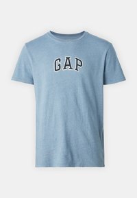 Helles blaues Baumwoll-T-Shirt mit kurzen Ärmeln und Rundhalsausschnitt. Mit dem „GAP“-Logo in schwarz umrandeten Buchstaben quer über die Brust.