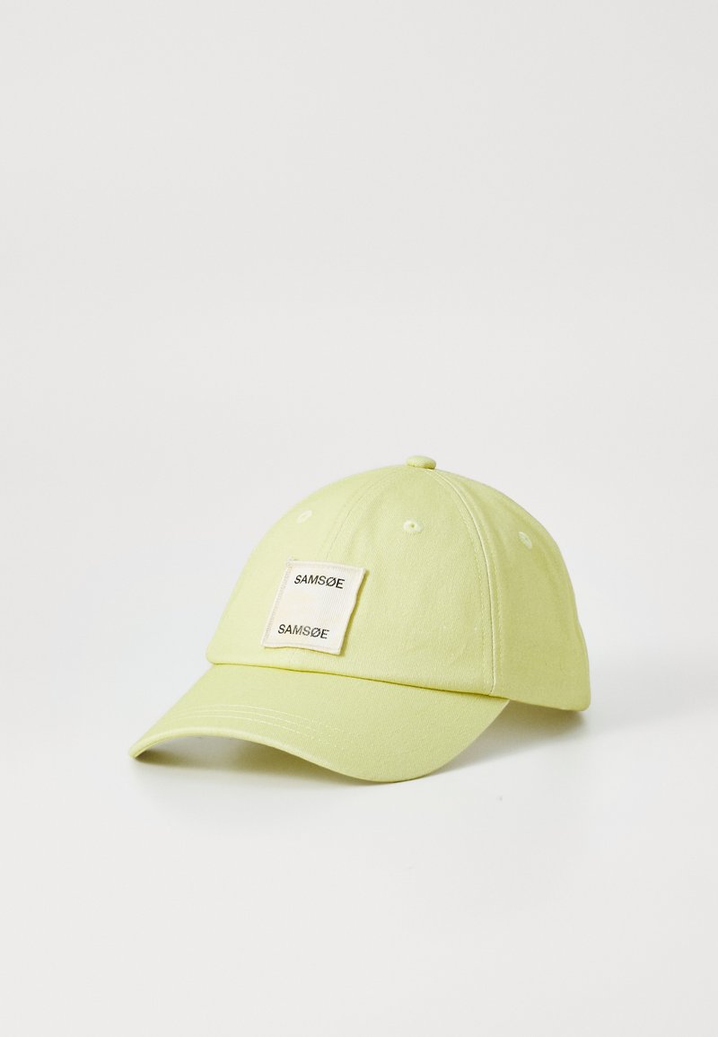 Cappellino da baseball in cotone giallo con visiera curva e un'etichetta rettangolare con la scritta "SAMSE". Il tessuto ha una consistenza liscia.