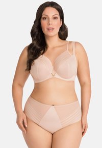 Beige bh en hooggesneden slip gemaakt van zacht, glad materiaal. De bh heeft een V-vormige hardware-accent, met gestreepte details op beide stukken.