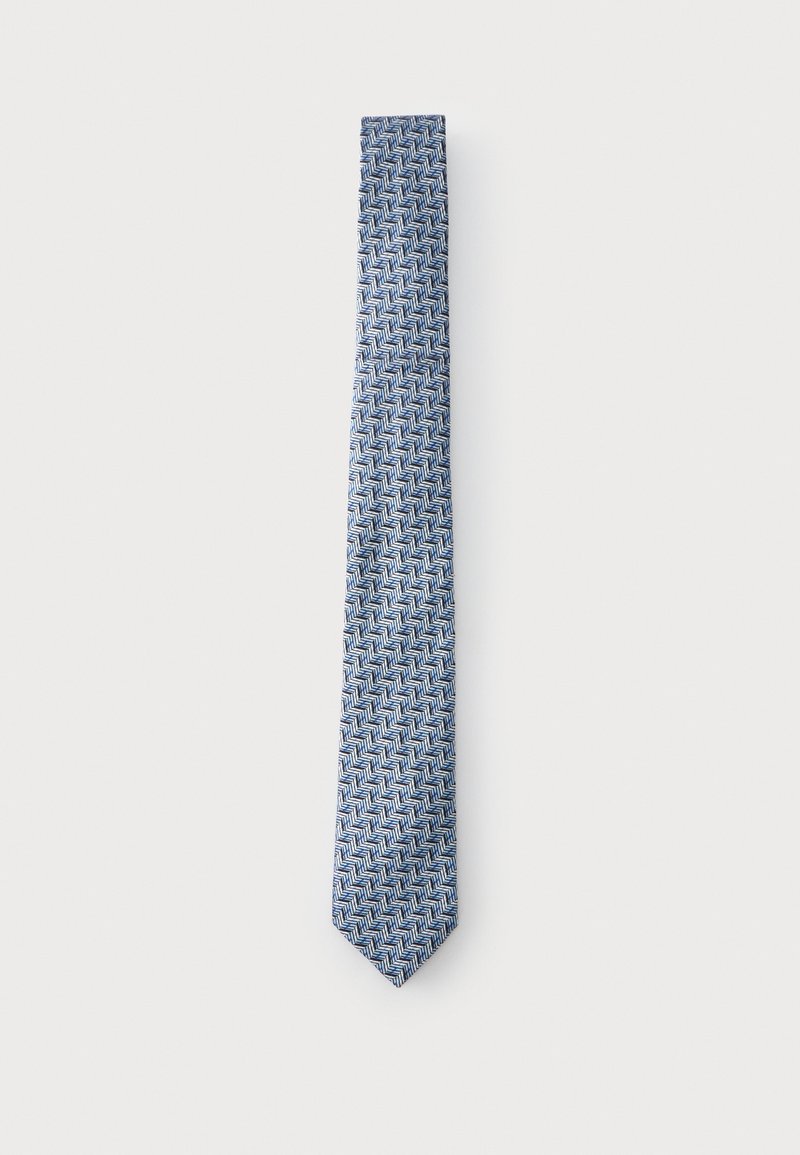 Cravate fine bleu et blanc à motif en chevrons affichée sur un fond clair uni.