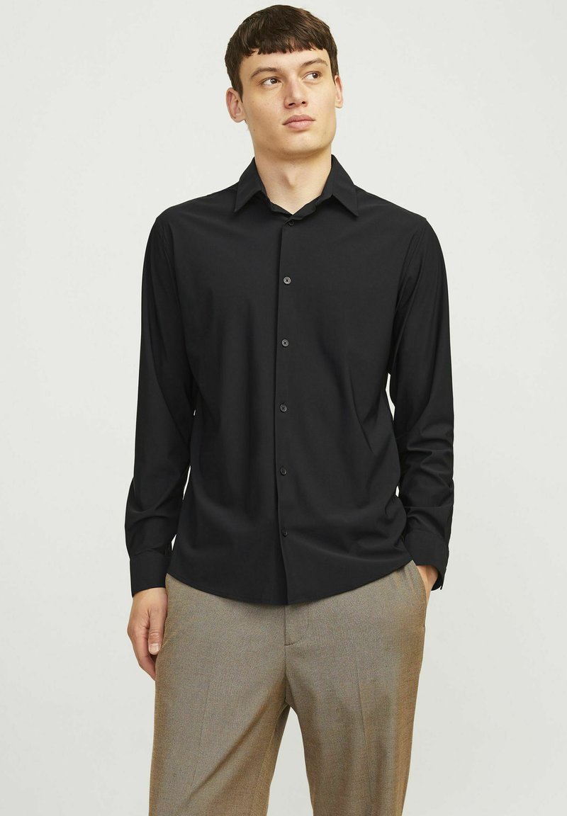 Camicia nera a maniche lunghe con bottoni, con colletto classico, realizzata in tessuto liscio, caratterizzata da un design attillato e dettagli di bottoni discreti.