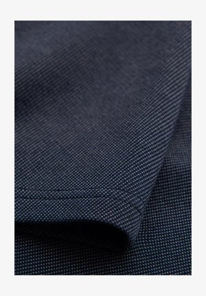 Granatowy materiał z teksturowanym wzorem, pokryty małymi białymi kropkami. Tkanina wydaje się wytrzymała i ciasno tkana, o gładkim wykończeniu.
