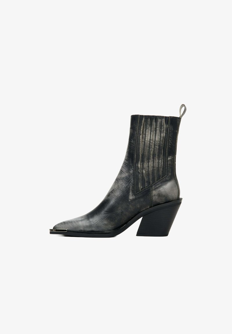 Czarne botki za kostkę z teksturowanej skóry, o spiczastym nosku, z pionowymi fałdami na cholewce i stożkowym obcasie. Posiadają pętelkę do zakupu.