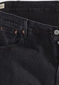 Zwarte spijkerbroek van denim met een gladde textuur, voorzien van koperen klinknagels en een knoopsluiting. De tailleband heeft een label en riemlussen.