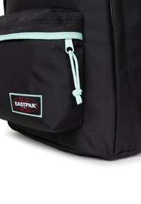 Zaino nero con tasca frontale dotata di una cerniera e dettagli azzurri. Il materiale è un tessuto testurizzato con un logo in evidenza.