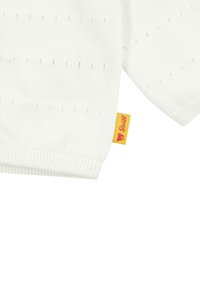 Maglione bianco lavorato a maglia con orlo a coste e un sottile motivo perforato. Include un piccolo etichetta gialla con testo rosso.