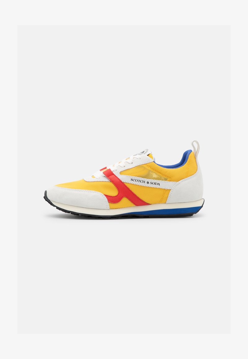 Sneakers with a yellow mesh upper, white suede accents, red side stripes, blue heel tab, and black rubber sole. Branding on the side.
