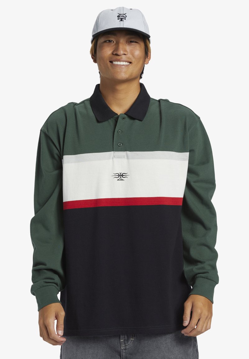 Polo à manches longues en vert, noir et blanc avec des rayures horizontales. Doté d'un col, de boutons et d'un petit logo sur la poitrine.